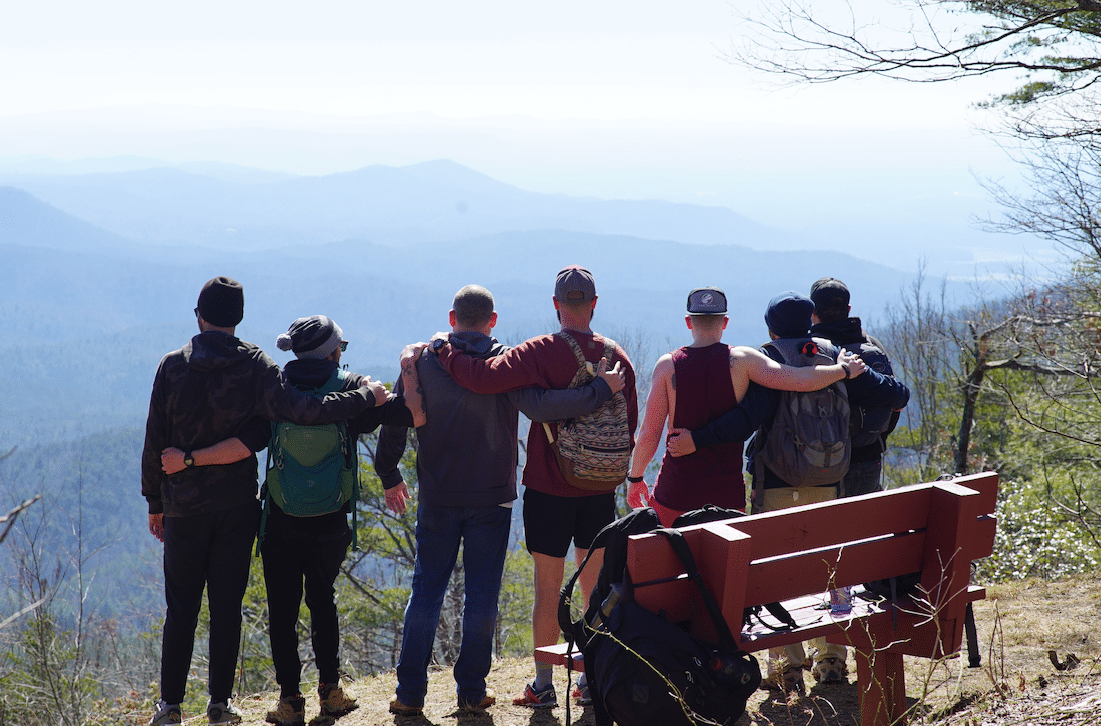 men hugging on a mountain